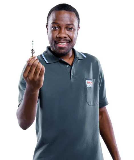  Mécanicien Bosch Car Service avec une bougie à la main